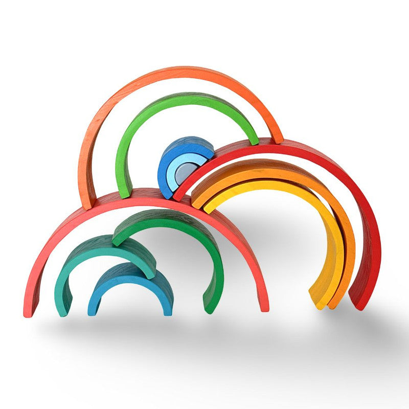 foto de un arcoiris desarmable de madera, donde cada color es un arco por su cuenta, mostrado siendo usado de forma creativa apilando los arcos en distintas formas