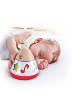 Niño pequeño interactuando con caja musical giratoria Hape, juguete para descubrir música y movimiento