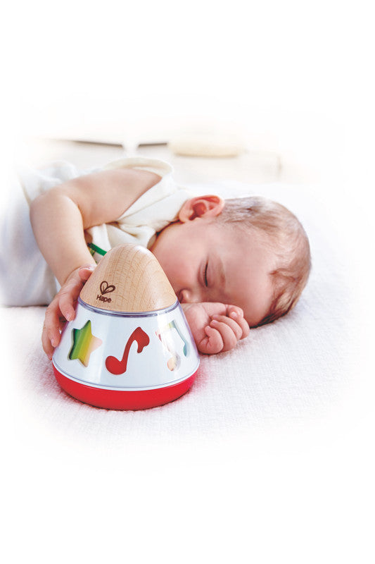 Niño pequeño interactuando con caja musical giratoria Hape, juguete para descubrir música y movimiento