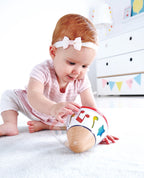 Bebé jugando con caja musical giratoria Hape, estimulación sonora y exploración temprana