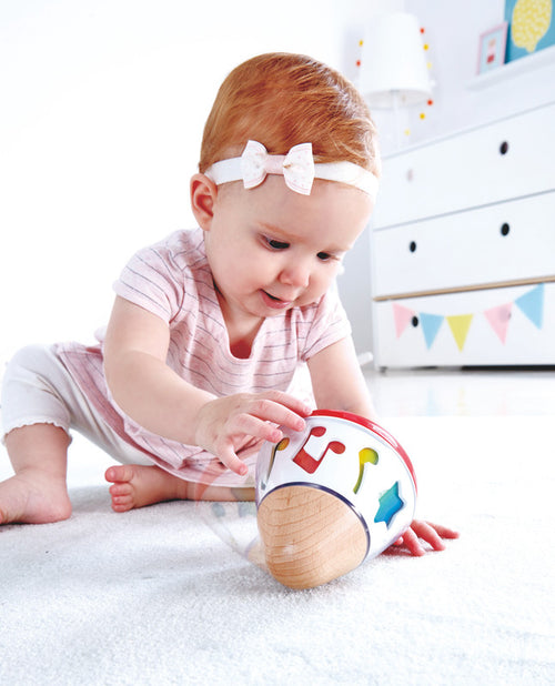 Bebé jugando con caja musical giratoria Hape, estimulación sonora y exploración temprana
